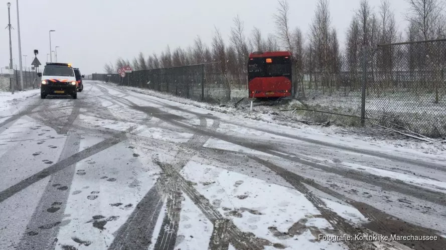 Bus glijdt door hek heen bij Schiphol