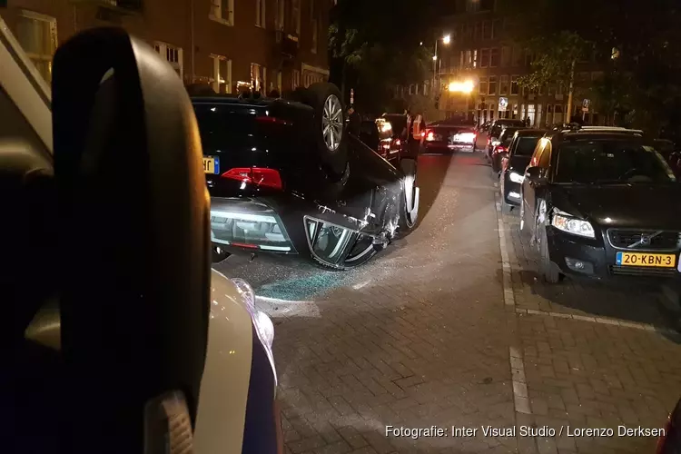 Auto op de kop in krappe Amsterdamse straat