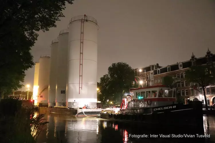 Metershoge silo’s door Amsterdamse grachten vervoerd