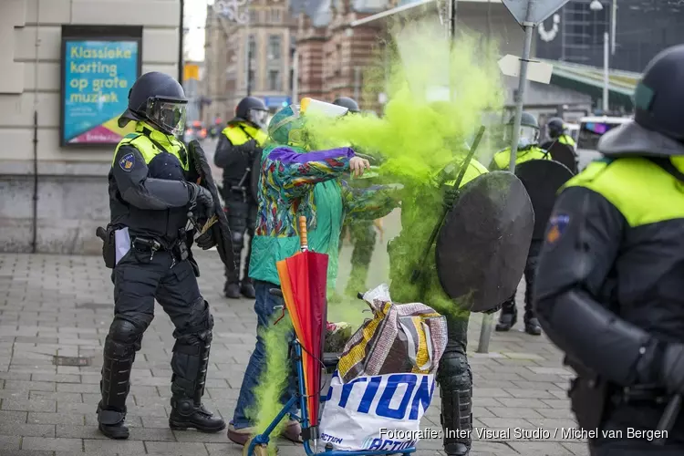 Oudere vrouw gooit poeder op agent bij Corona-rellen in Amsterdam