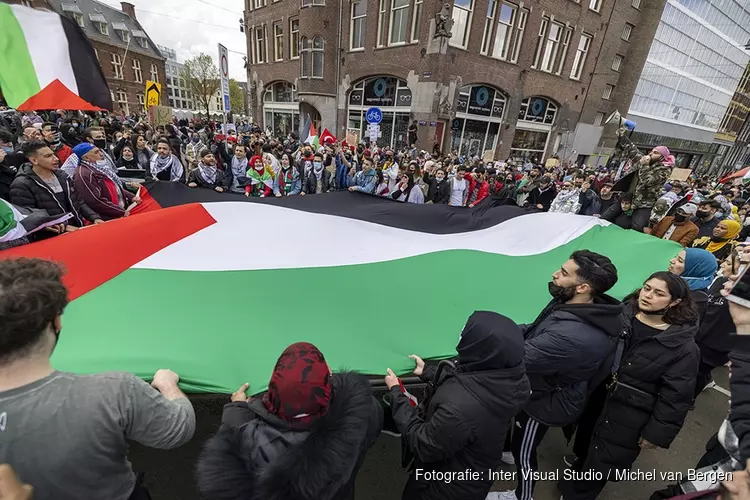 Demonstranten lopen van de Dam naar het Amstelstation