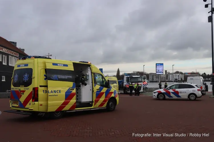 Reddingsactie persoon te water achter Amsterdam Centraal