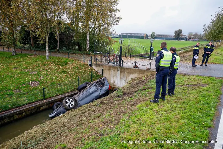 Auto op de kop in de sloot in Weesp, politie doet onderzoek