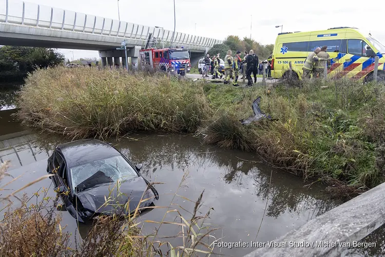 Automobilist te water langs de Osdorperweg in Amsterdam